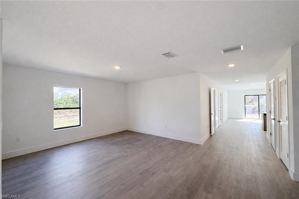 108 Indiana Place Lehigh Acres, FL 33936 - Photo 5 of 19 Spare room with light wood-type flooring, a textured ceiling, and recessed lighting