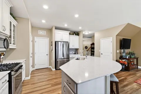 a kitchen with stainless steel appliances a stove refrigerator sink and stove