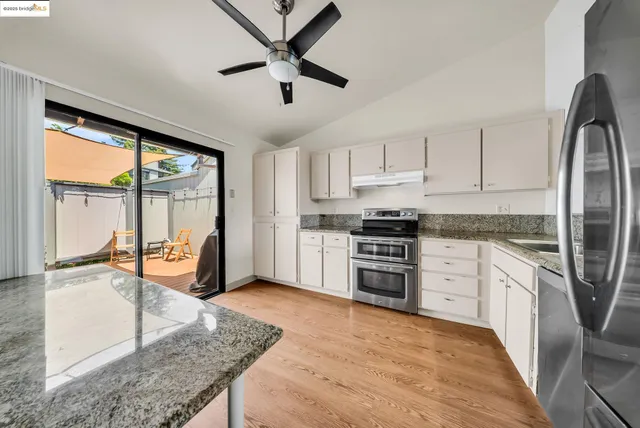a kitchen with stainless steel appliances granite countertop a stove a sink and a refrigerator