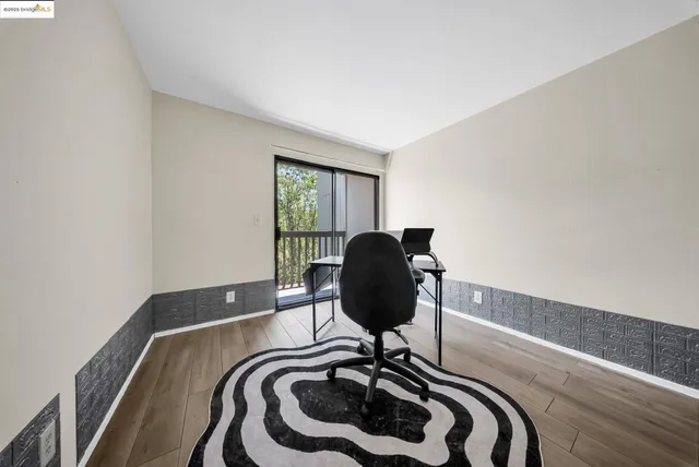 a view of a workspace with furniture and a window