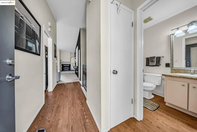 a bathroom with a granite countertop toilet a sink and a mirror