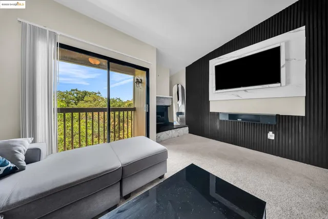 a living room with a bed and a flat tv screen