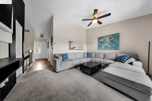 a living room with furniture and a ceiling fan