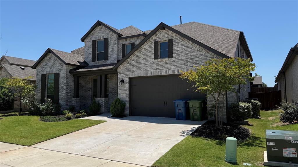 9628 Boulder Pt Road Oak Point, TX 75068 - Photo 2 of 35 Gray brick two-story residence featuring a two-car garage, dark brown shutters, and a covered front entry