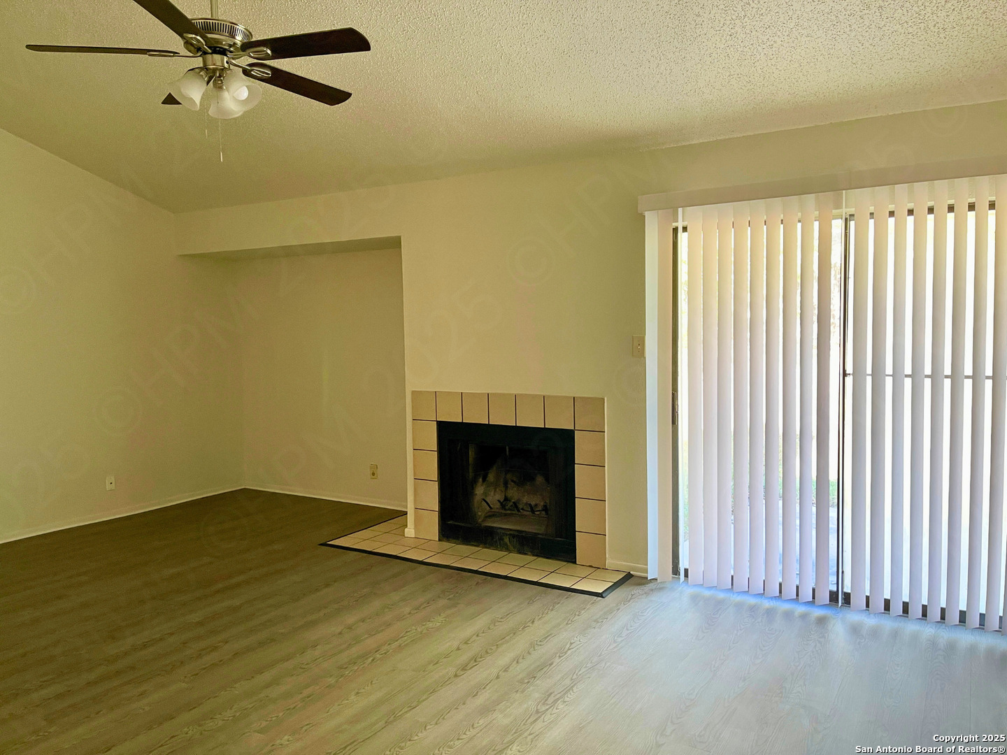 7315 Ridge Beach Drive Converse, TX 78109 - Photo 10 of 17 an empty room with wooden floor fireplace and windows