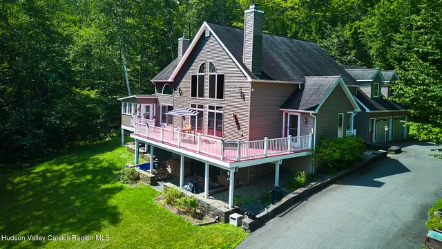 an aerial view of a house with a yard balcony and wooden fence