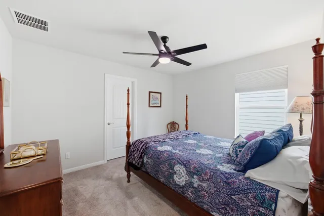 a bedroom with a bed and a potted plant