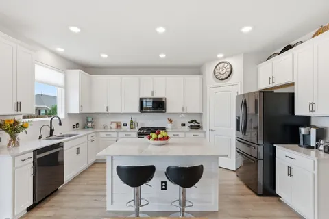 a living room with furniture kitchen view and a flat screen tv
