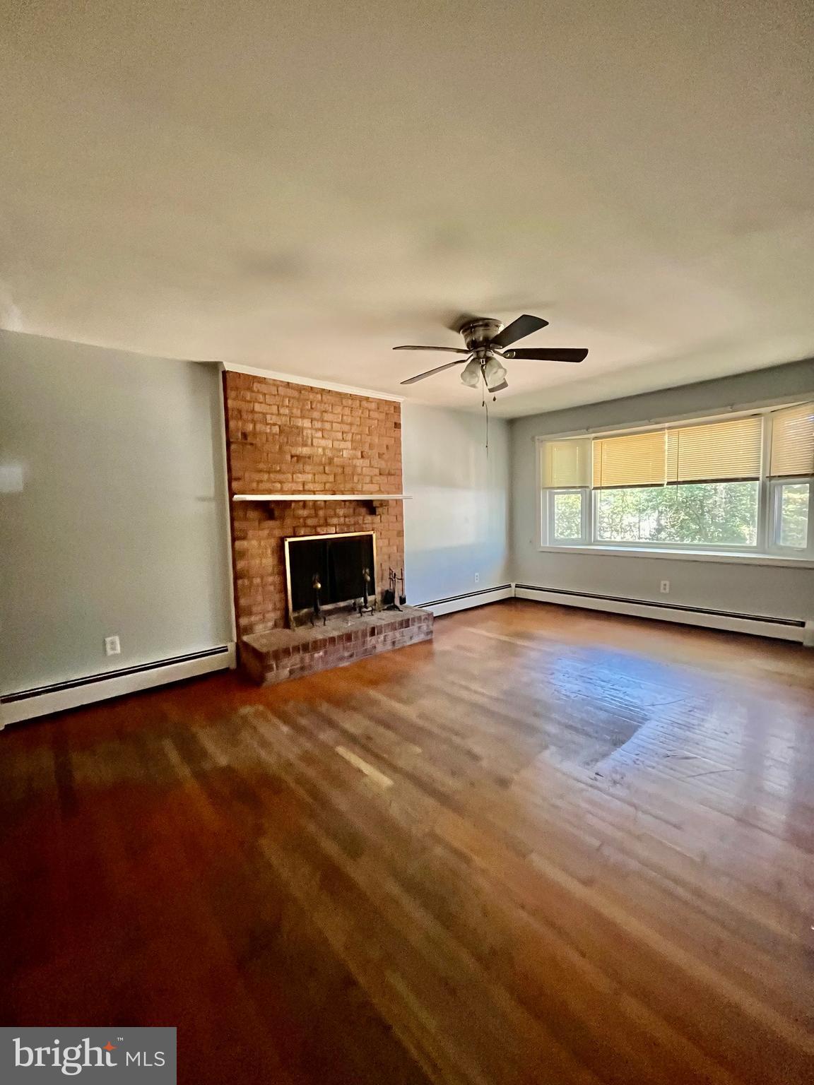 4302 Baxter Road Prince George, VA 23875 - Photo 57 of 78 an empty room with wooden floor fireplace and windows