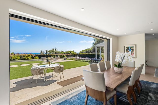 a dining room with furniture and floor to ceiling window