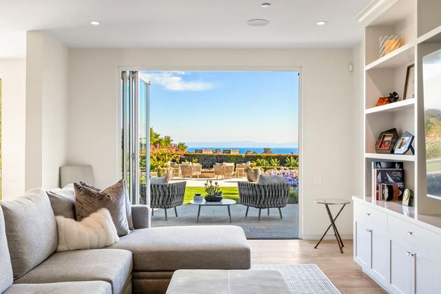 a living room with furniture and a floor to ceiling window