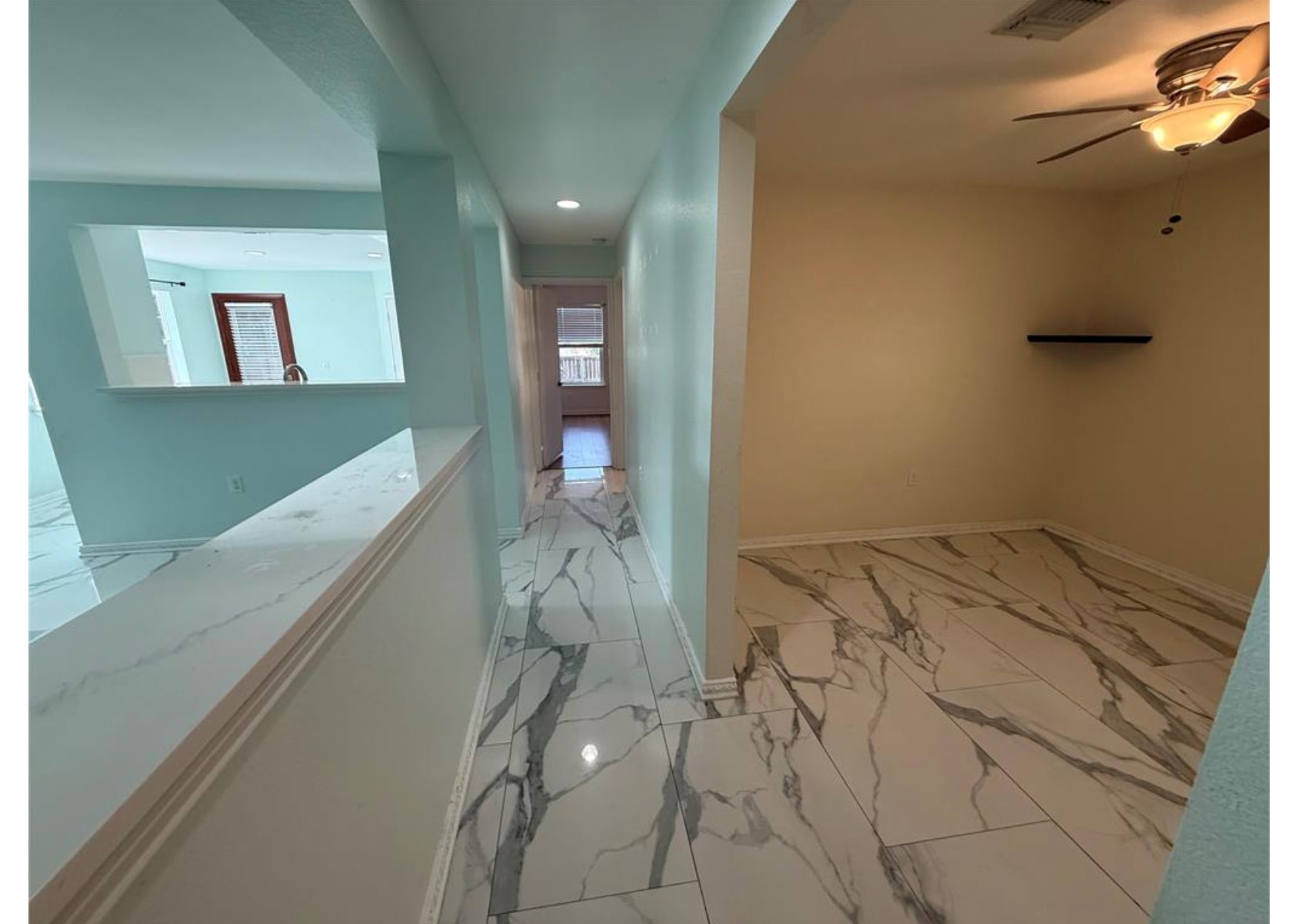 6600 Glebe Path Austin, TX 78754 - Photo 8 of 10 Marble-look tile flooring flows throughout this modern hallway and adjoining room, creating a seamless aesthetic.