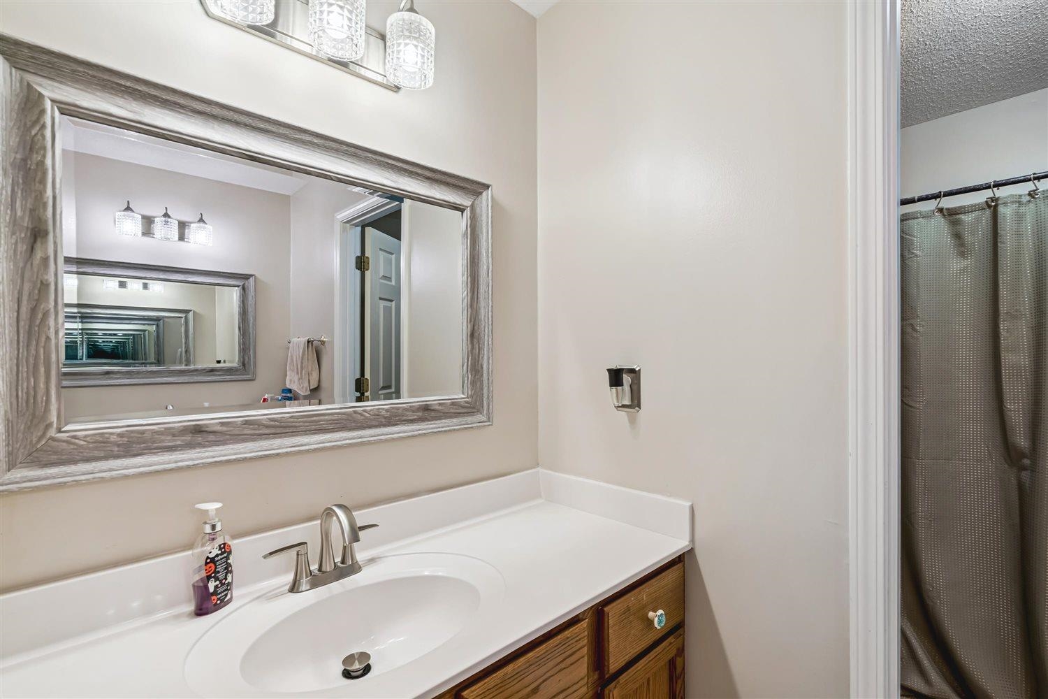 1489 John Ridge Drive Collierville, TN 38017 - Photo 30 of 39 a bathroom with a sink and a mirror