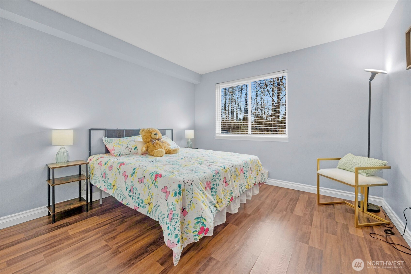 1001 West Casino Road, Unit B101 Everett, WA 98204 - Photo 15 of 19 a bedroom with a bed a chair and a wooden floor