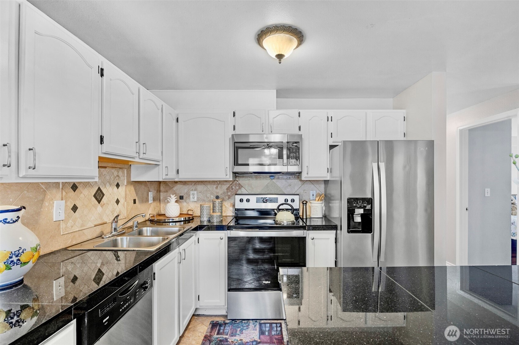 1001 West Casino Road, Unit B101 Everett, WA 98204 - Photo 8 of 19 a kitchen with stainless steel appliances granite countertop a stove refrigerator sink and cabinets
