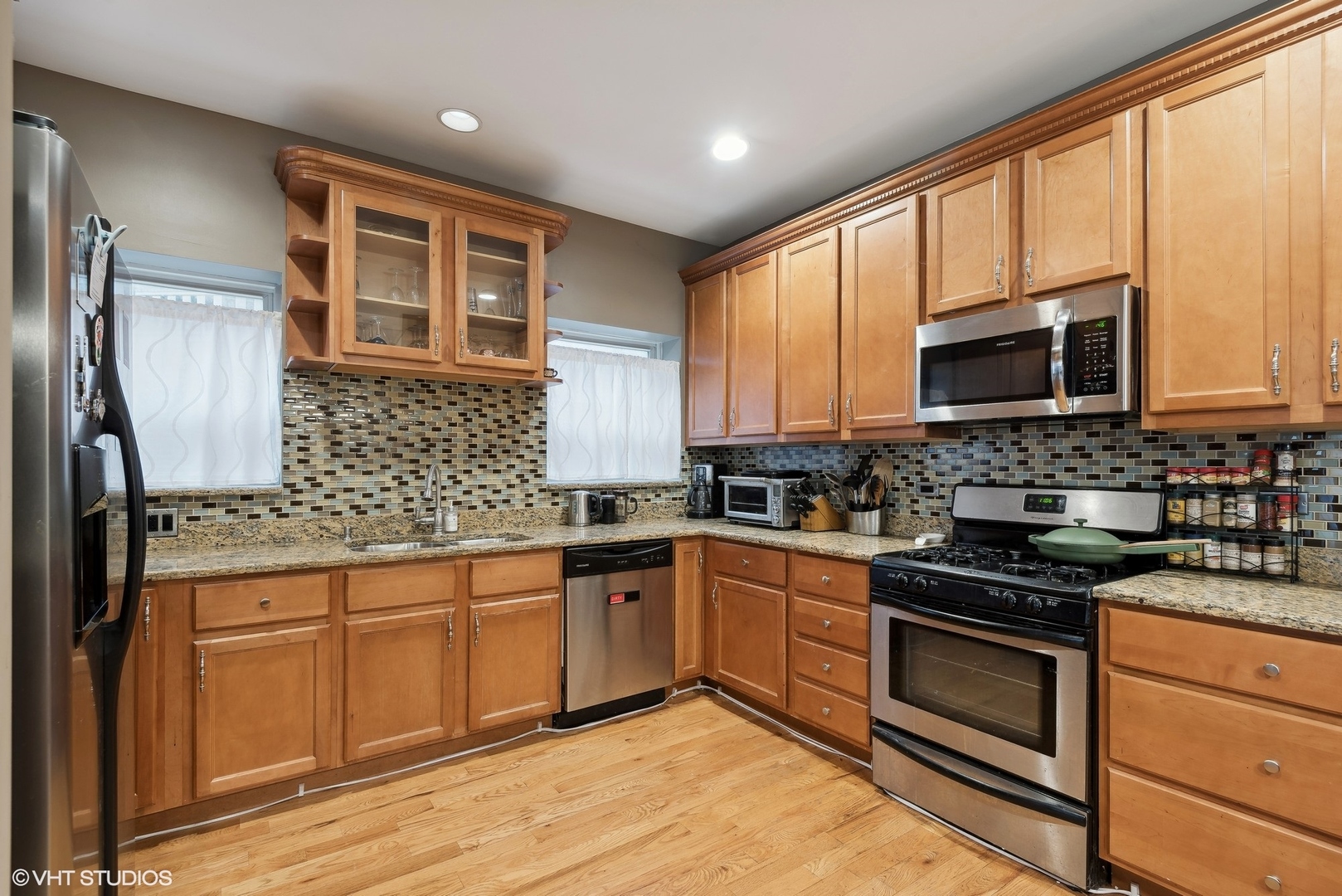 1116 East 46th Street, Unit 3W Chicago, IL 60653 - Photo 6 of 16 a kitchen with stainless steel appliances granite countertop wooden cabinets granite counter tops and a window