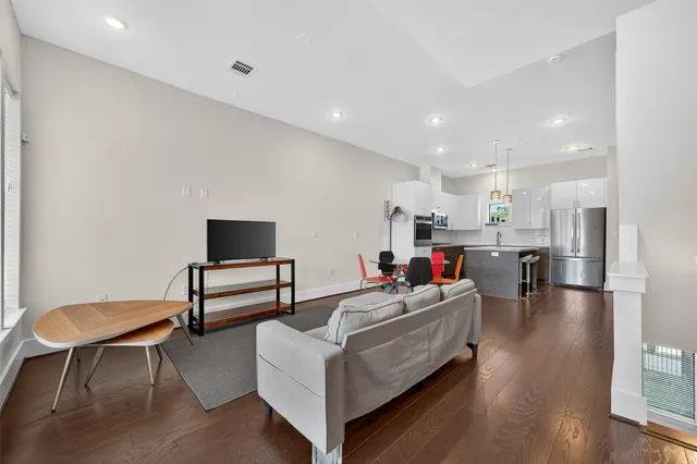a living room with furniture and a wooden floor