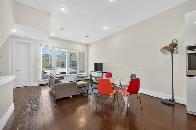 a kitchen with stainless steel appliances granite countertop a refrigerator a sink dishwasher a stove and white countertops with wooden floor