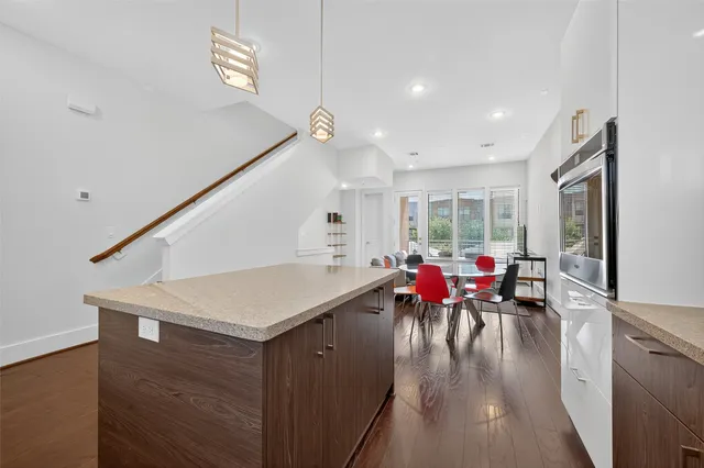 a large kitchen with stainless steel appliances a large counter top a stove and a refrigerator