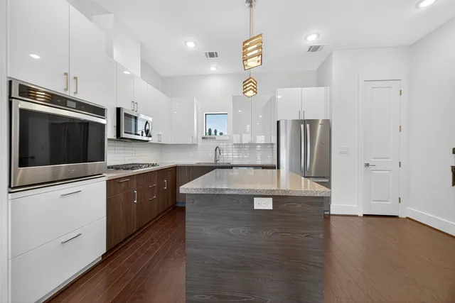 a kitchen with stainless steel appliances granite countertop a sink a stove and cabinets