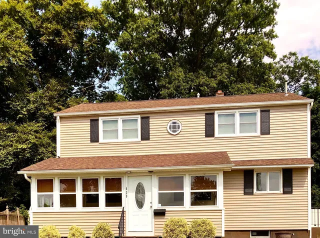 a front view of a house with a tree