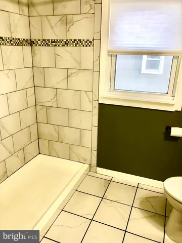 a bathroom with a granite countertop toilet and a sink