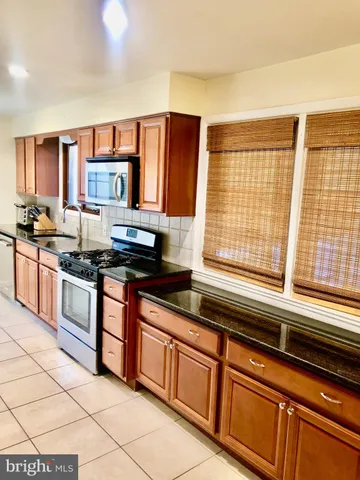 a kitchen with stainless steel appliances a sink stove and cabinets