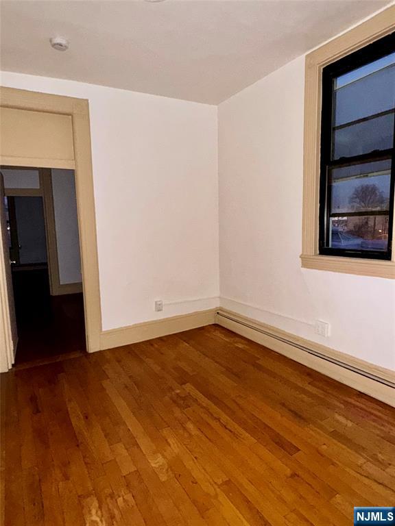 108 32nd Street Union City, NJ 07087 - Photo 5 of 10 a view of an empty room with wooden floor and a window