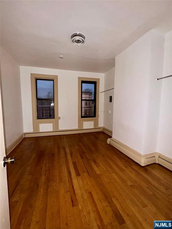 108 32nd Street Union City, NJ 07087 - Photo 8 of 10 a view of an empty room with wooden floor and a window