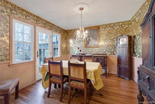 a dining room with furniture a chandelier and wooden floor