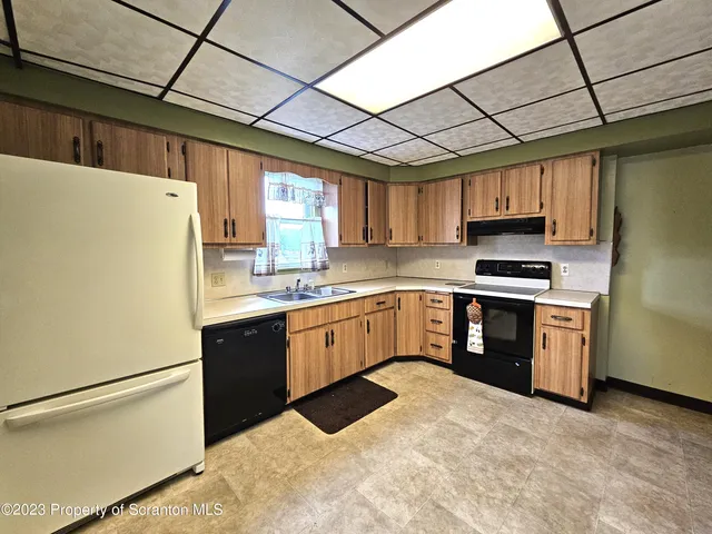 a kitchen with stainless steel appliances granite countertop a refrigerator a sink dishwasher a stove top oven a kitchen island and cabinets with wooden floor