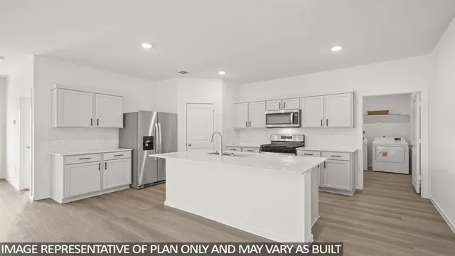 a kitchen with stainless steel appliances a refrigerator stove and white cabinets