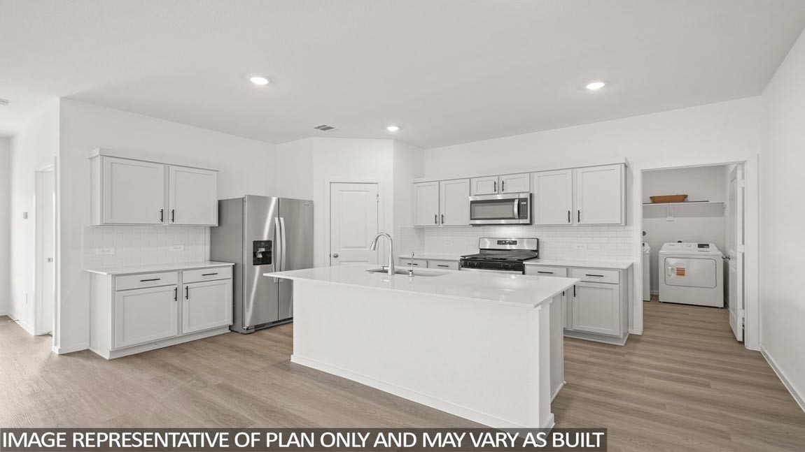 a kitchen with stainless steel appliances a refrigerator stove and white cabinets