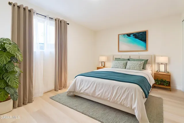 a bedroom with a bed and a potted plant