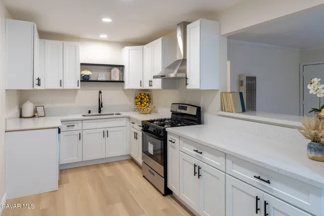 a kitchen with cabinets appliances a sink and a counter top space