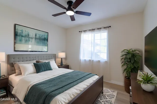 a bedroom with bed and a potted plant