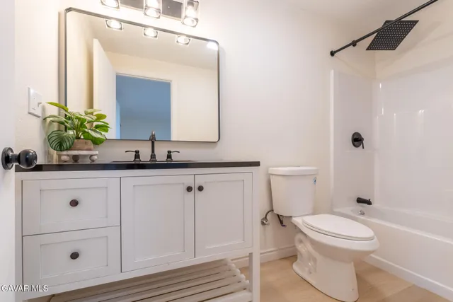 a bathroom with a toilet a sink and a mirror