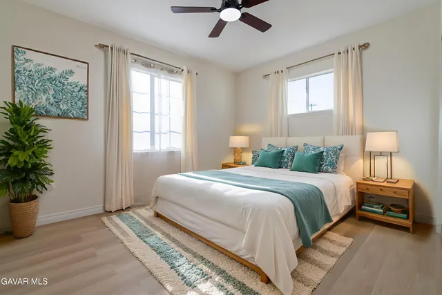 a bedroom with a large bed and a potted plant