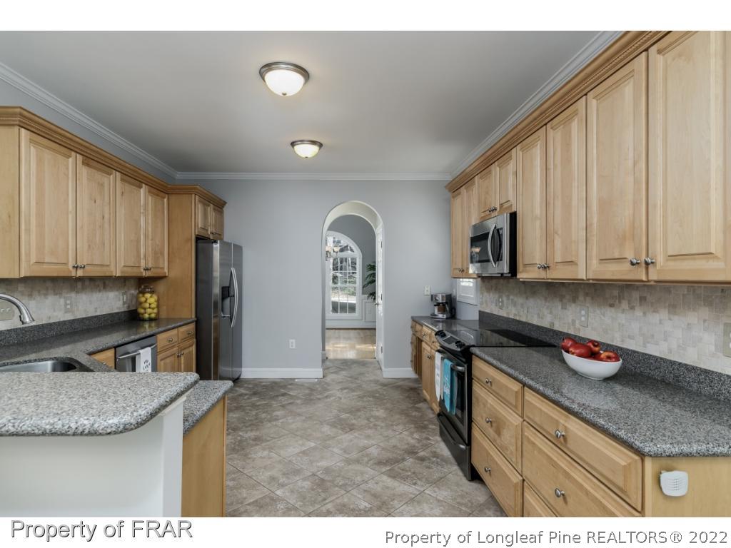 460 Elk Road Southern Pines, NC 28387 - Photo 8 of 30 a kitchen with stainless steel appliances granite countertop a sink refrigerator and cabinets