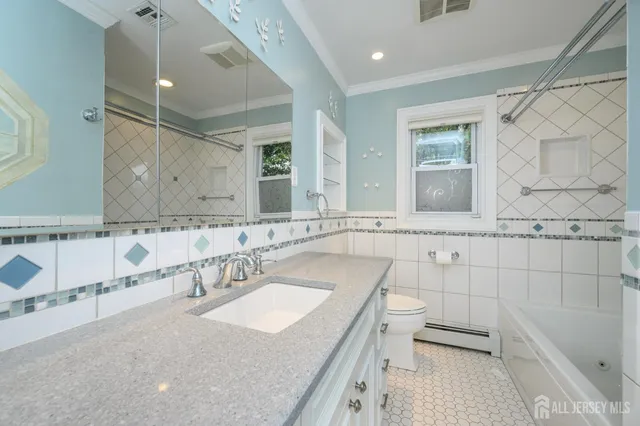 a bathroom with a granite countertop sink a mirror and a bathtub