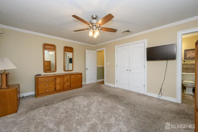 a living room with a ceiling fan and a dresser