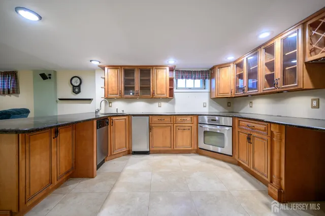 a kitchen with stainless steel appliances granite countertop a stove sink and cabinets