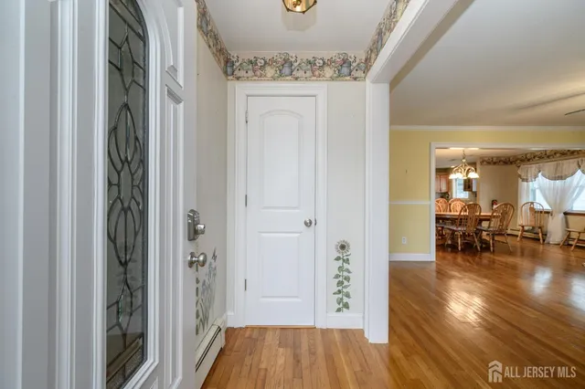 a view of a hallway and dining room with wooden floor