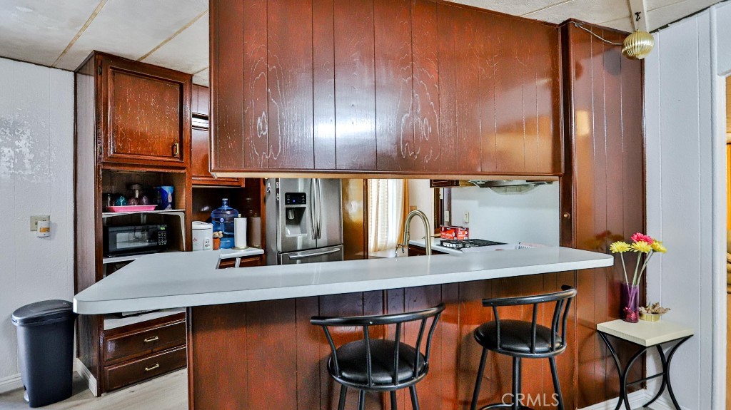 14300 Clinton Street, Unit 64 Garden Grove, CA 92843 - Photo 17 of 48 a kitchen with stainless steel appliances a table and chairs in it