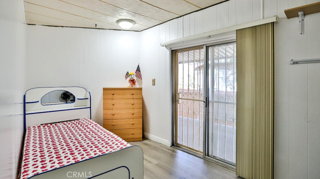 14300 Clinton Street, Unit 64 Garden Grove, CA 92843 - Photo 26 of 48 a bedroom with a bed and wooden floor