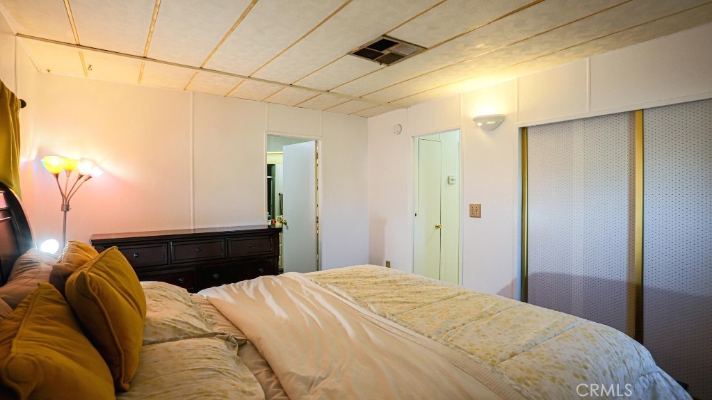 14300 Clinton Street, Unit 64 Garden Grove, CA 92843 - Photo 33 of 48 a bedroom with a bed and a chandelier