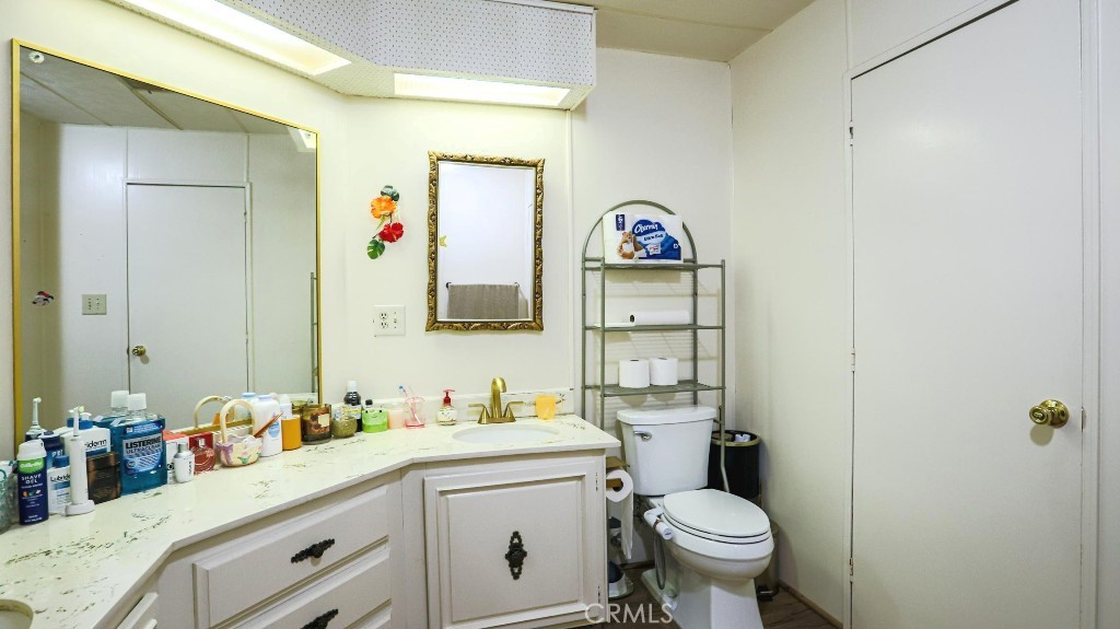 14300 Clinton Street, Unit 64 Garden Grove, CA 92843 - Photo 37 of 48 a bathroom with a toilet sink and mirror