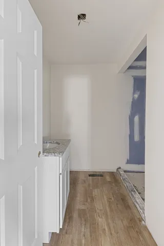 a view of empty room with wooden floor and ceiling fan