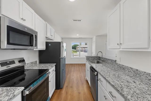 a kitchen with stainless steel appliances granite countertop a refrigerator and a sink