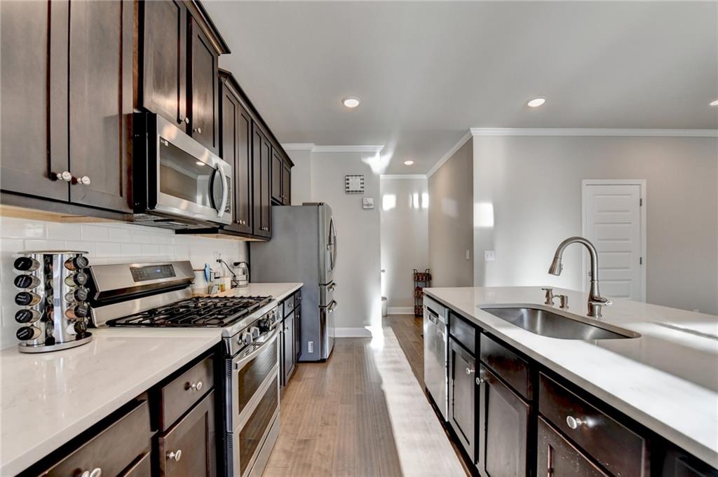 2230 Manor Pointe Drive Cumming, GA 30041 - Photo 11 of 53 a kitchen with stainless steel appliances a sink stove and cabinets